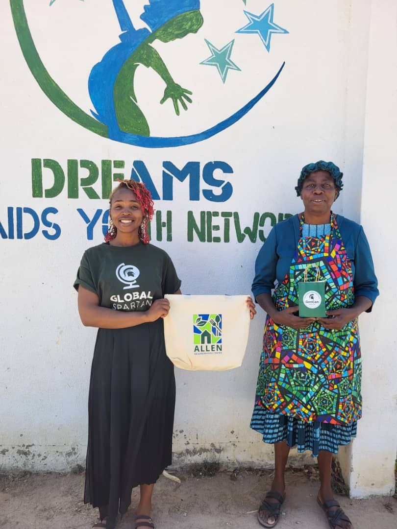 DREAMS team and partner standing by the DREAMS wall logo